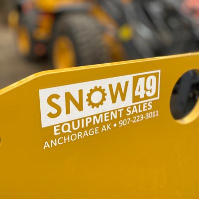 The Snow 49 logo on a metal pless plow in the shop with shallow depth of field